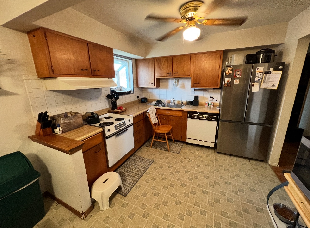 Kitchen renovation after - older kitchen with wood cabinets and white appliances